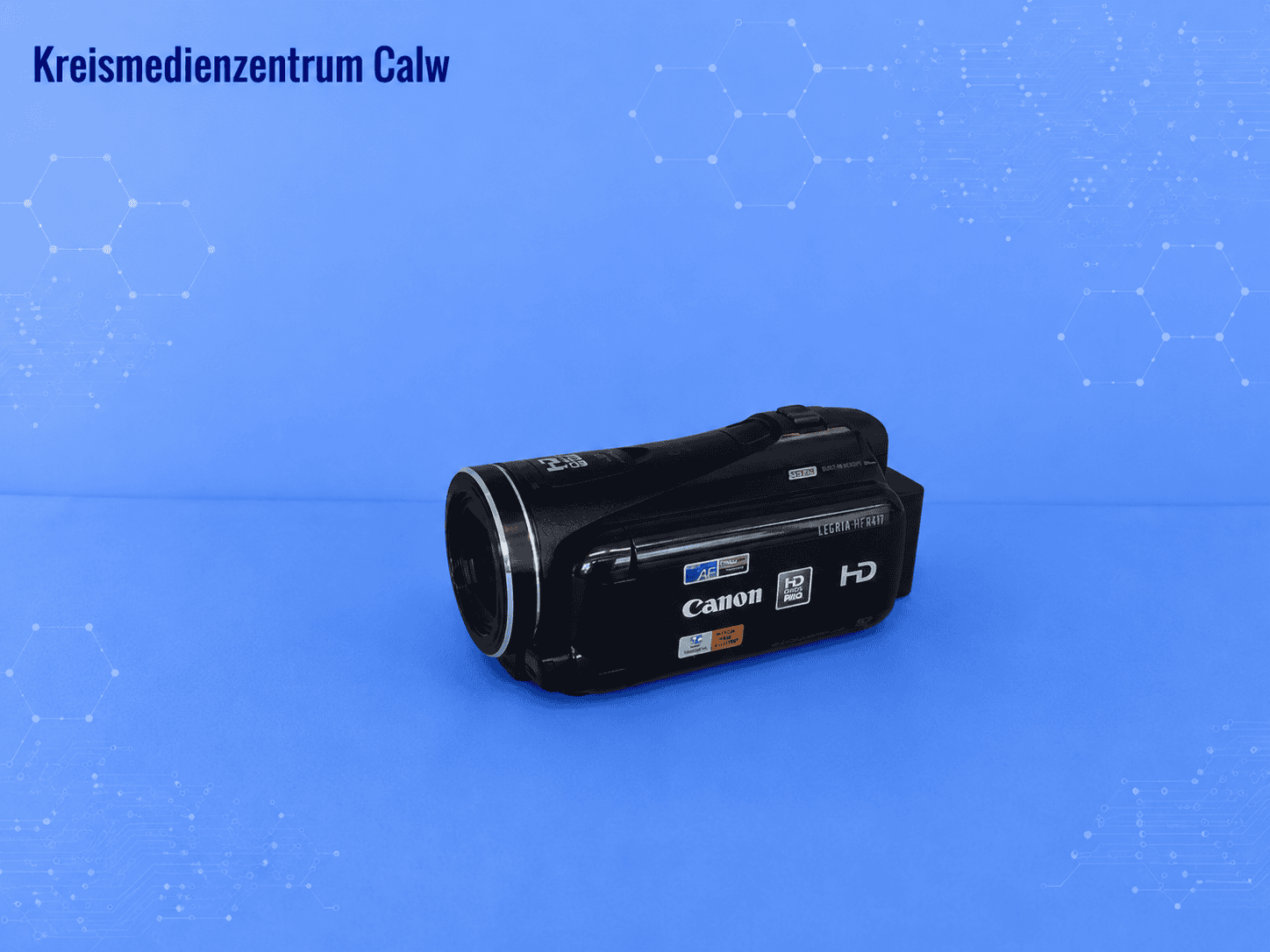 Canon Camcorder LEGRIA HF M41 vor blauem Hintergrund mit Hexagon-Muster.