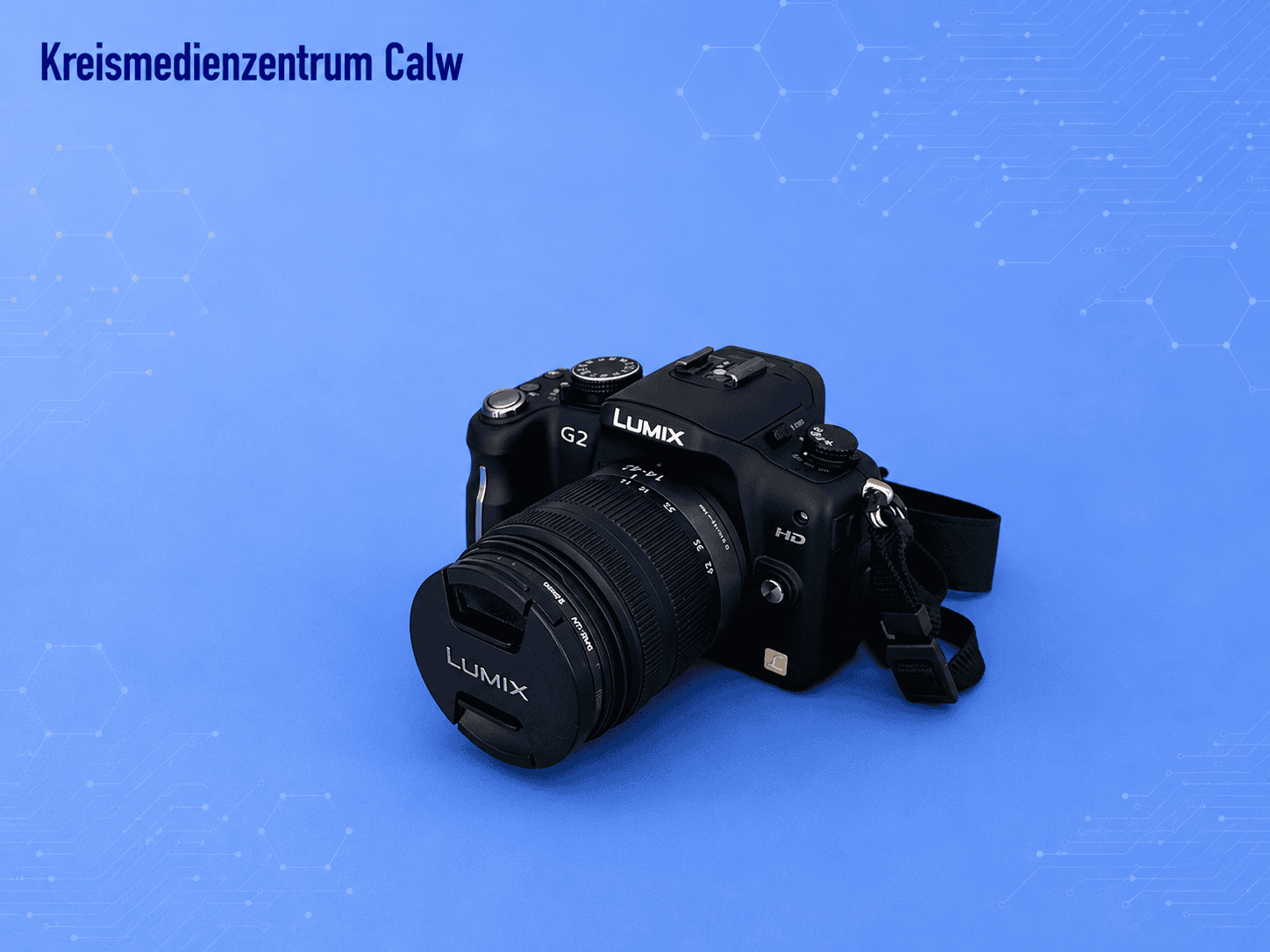Panasonic Lumix DMC-G2 Kamera auf blauer Hintergrund mit Hexagon-Mustern.